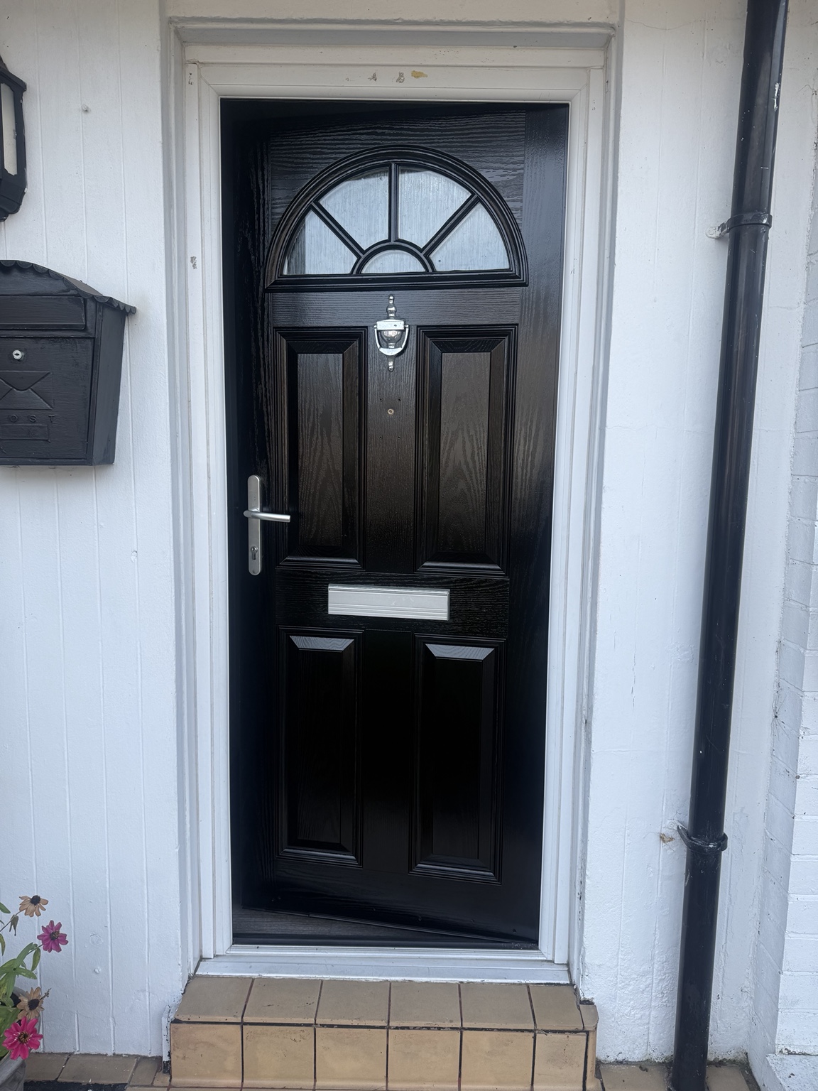 Black front door following a No1 MCR Handyman spraying project